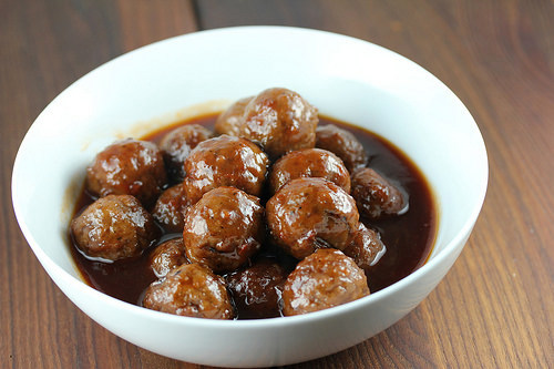 Meatballs served in a white bowl with thick savory sauce