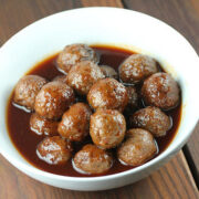 Meatballs served in a white bowl with thick savory sauce