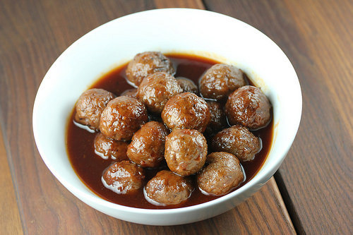 Meatballs served in a white bowl with thick savory sauce
