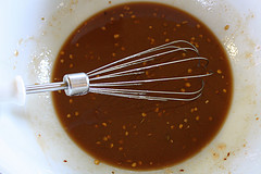 Whisk mixing spicy Szechuan sauce in a bowl