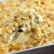 Spoonful of creamy tuna casserole topped with crushed potato chips