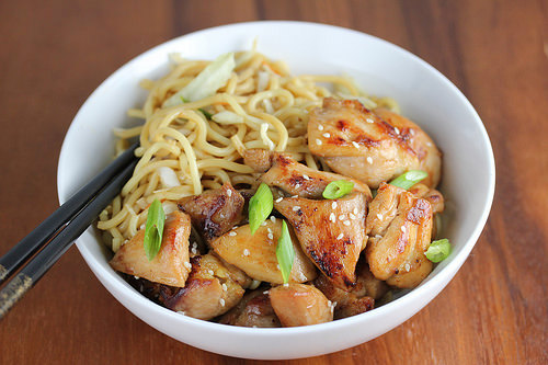 Bowl of chicken noodles with sesame and scallions