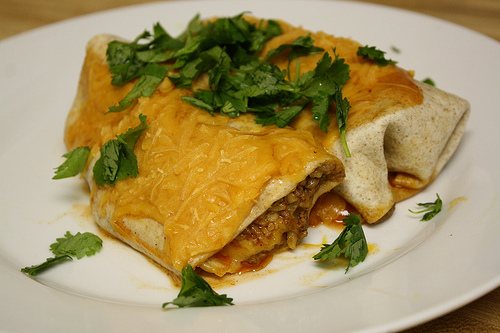Cheesy beef burrito topped with cilantro
