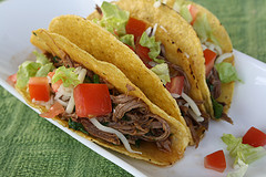 Beef tacos topped with lettuce and tomatoes
