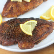 Blackened chicken topped with lemon wedges