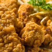Baked chicken tenders with crispy coating and parsley garnish