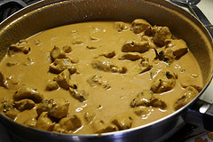Chicken simmering in a creamy sauce in a skillet