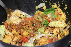 Ground beef taco salad being mixed in a bowl