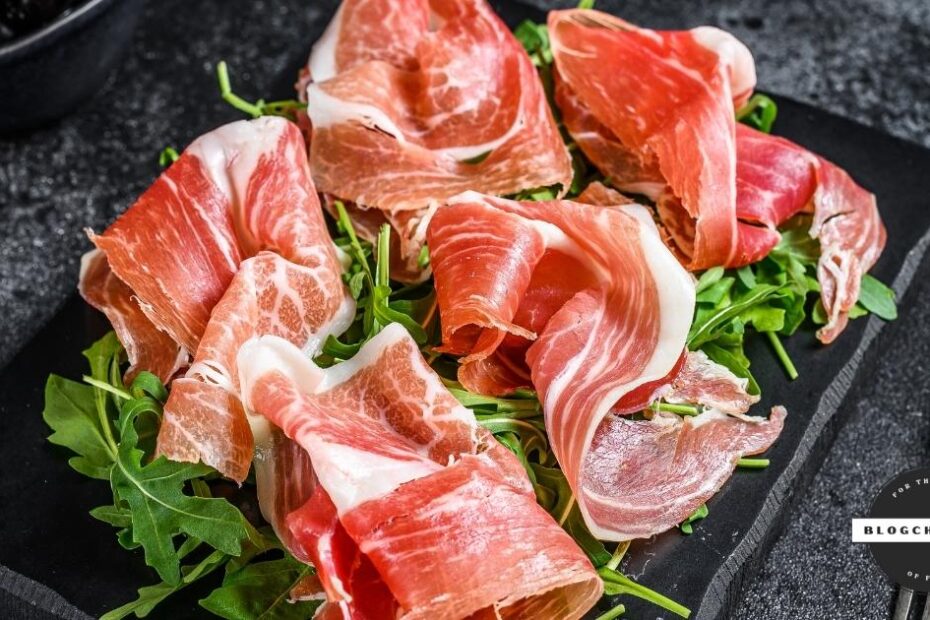Slices of prosciutto arranged on arugula leaves