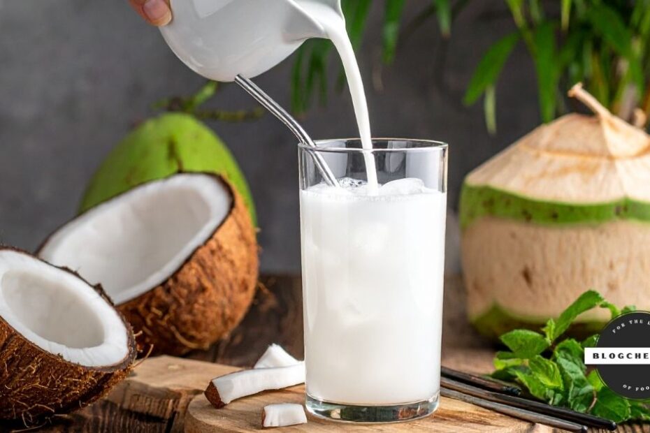 Pouring coconut milk into glass with coconuts