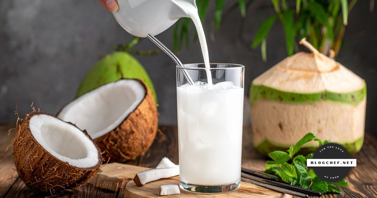 Pouring coconut milk into glass with coconuts