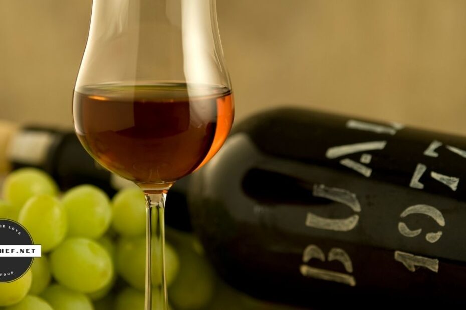 Glass of madeira wine with bottle and grapes in background