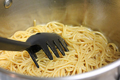 Cooked noodles in a pot with a pasta spoon