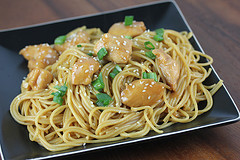Chinese chicken noodles served on a black plate