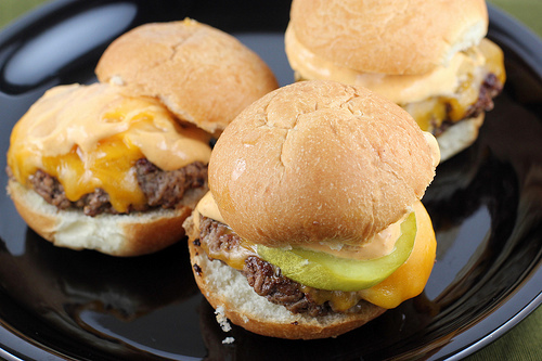 Cheeseburger sliders with melted cheese, pickles, and sauce