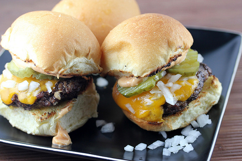Plate of cheeseburger sliders with toppings
