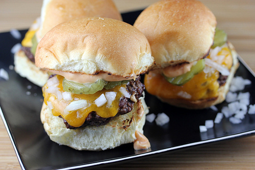 Cheeseburger sliders topped with pickles and onions