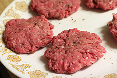 Raw hamburger patties seasoned with black pepper