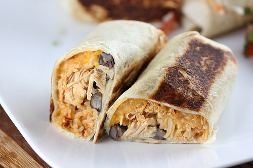 Cheesy chicken burrito halves on plate