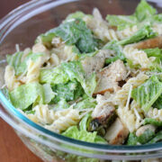 Prepared chicken caesar pasta salad in a clear glass bowl