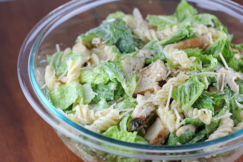 Prepared chicken caesar pasta salad in a clear glass bowl