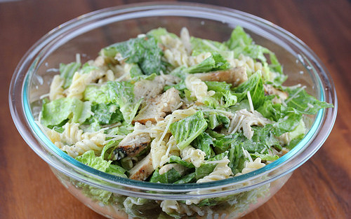 Close view of chicken caesar pasta salad mixed with romaine and pasta