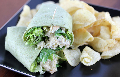 Chicken Caesar salad wrap sliced open with lettuce and chicken showing