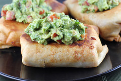 Close-up of a fried chimichanga topped with chunky guacamole
