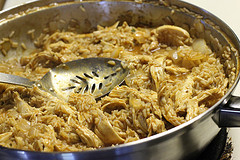 Shredded chicken and rice cooking together in a skillet