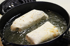 Tortillas frying in hot oil in a skillet