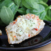 Sliced chicken french bread pizza served with fresh spinach