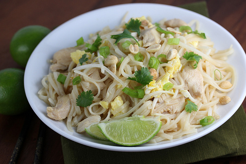 Chicken pad thai garnished with green onions