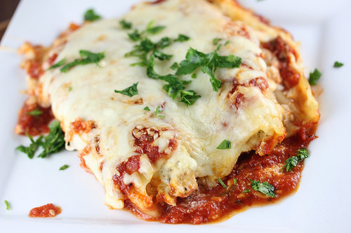 Baked chicken parmesan manicotti topped with melted cheese