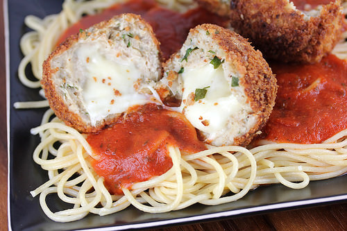 Chicken parmesan meatballs on spaghetti topped with marinara