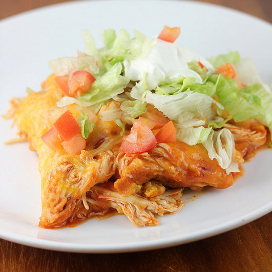 Plated chicken tamale bake topped with lettuce, tomatoes, and sour cream