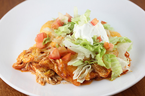 Chicken tamale bake with shredded lettuce, tomatoes, and sour cream