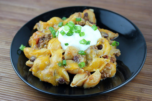 Cheesy chili pasta served with sour cream and green onions
