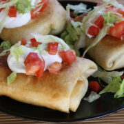 Crispy chimichangas topped with sour cream and vegetables