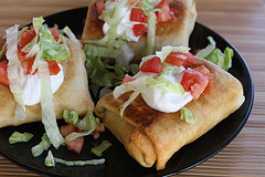 Golden chimichangas served with fresh toppings
