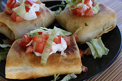 Crispy chimichangas topped with lettuce, tomato, and sour cream