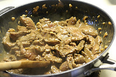 Marinated beef cooking in a skillet