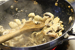 Sliced mushrooms sautéing in a pan