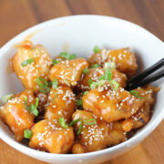 Sauced Chinese chicken balls topped with sesame seeds and green onions