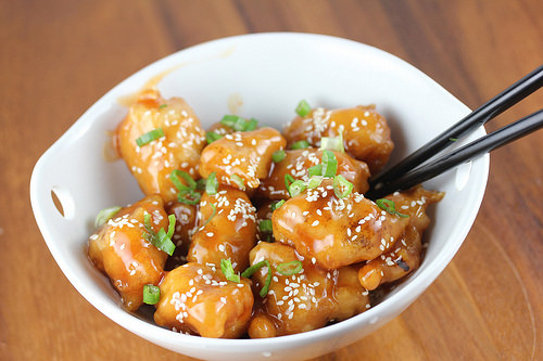Sauced Chinese chicken balls topped with sesame seeds and green onions