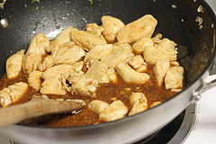 Chicken cooking in a wok with sauce