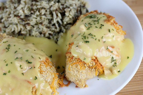 Chicken topped with creamy cheddar sauce on a plate