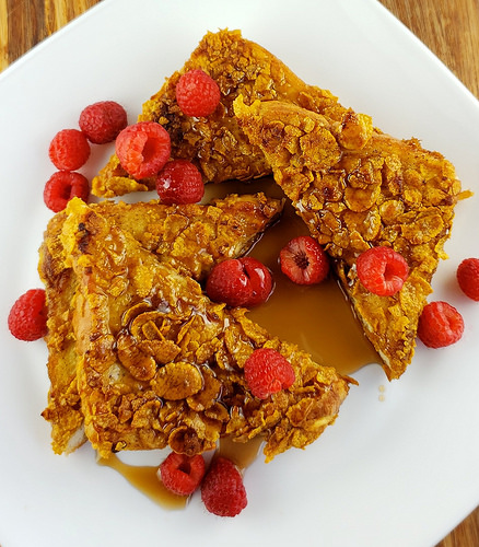 Crunchy French toast slices with raspberries and syrup