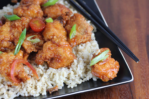 Crispy chicken pieces served over rice with green onions