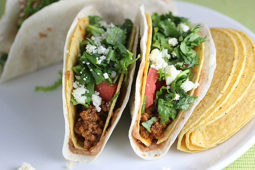 Double decker tacos filled with seasoned beef lettuce tomatoes and cheese