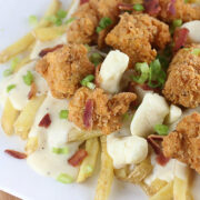 Fried chicken poutine with fries, cheese curds, gravy, chicken, bacon, and green onions